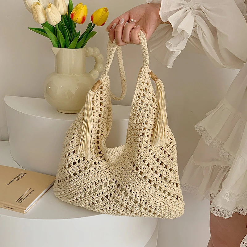 A single-shoulder hand-held women's bag made of straw with a drawstring inner pocket